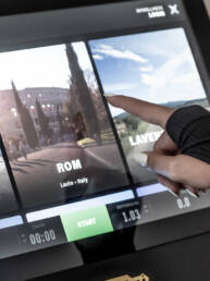 Frau nutzt ein Touchscreen-Display an einem modernen Trainingsgerät im Fitness Park Charly im Westerwald.