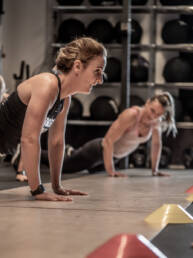 Frauen absolvieren Liegestütze während eines Functional-Fitness-Trainings in der Athletic Box des Fitness Park Charly bei Montabaur.